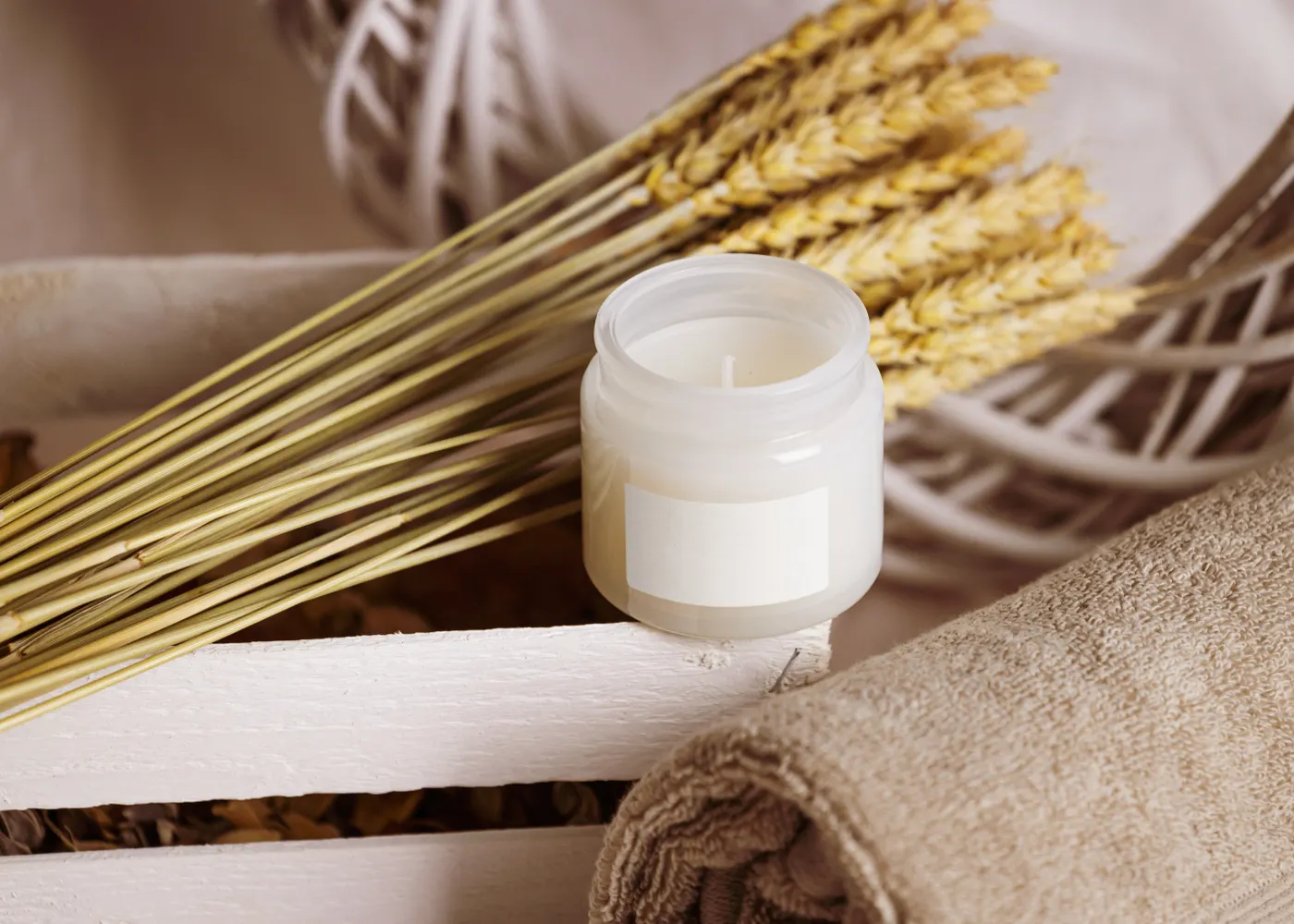Candle, soft towel and dried wheat arranged as a gift